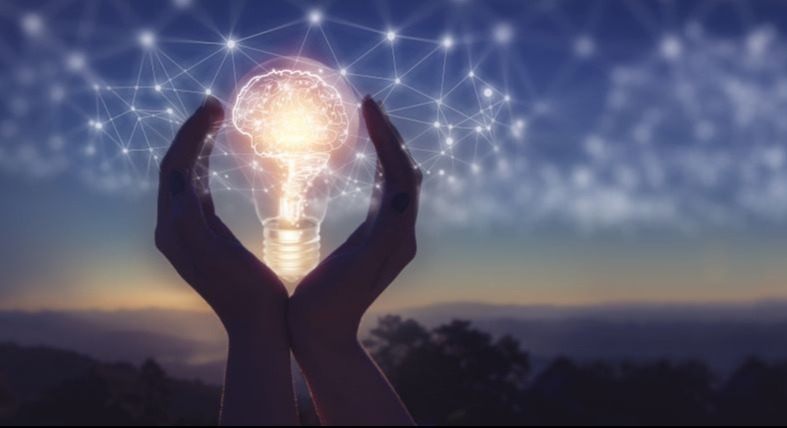 Hands holding a digital lightbulb with the graphic of a brain and cyber connections.