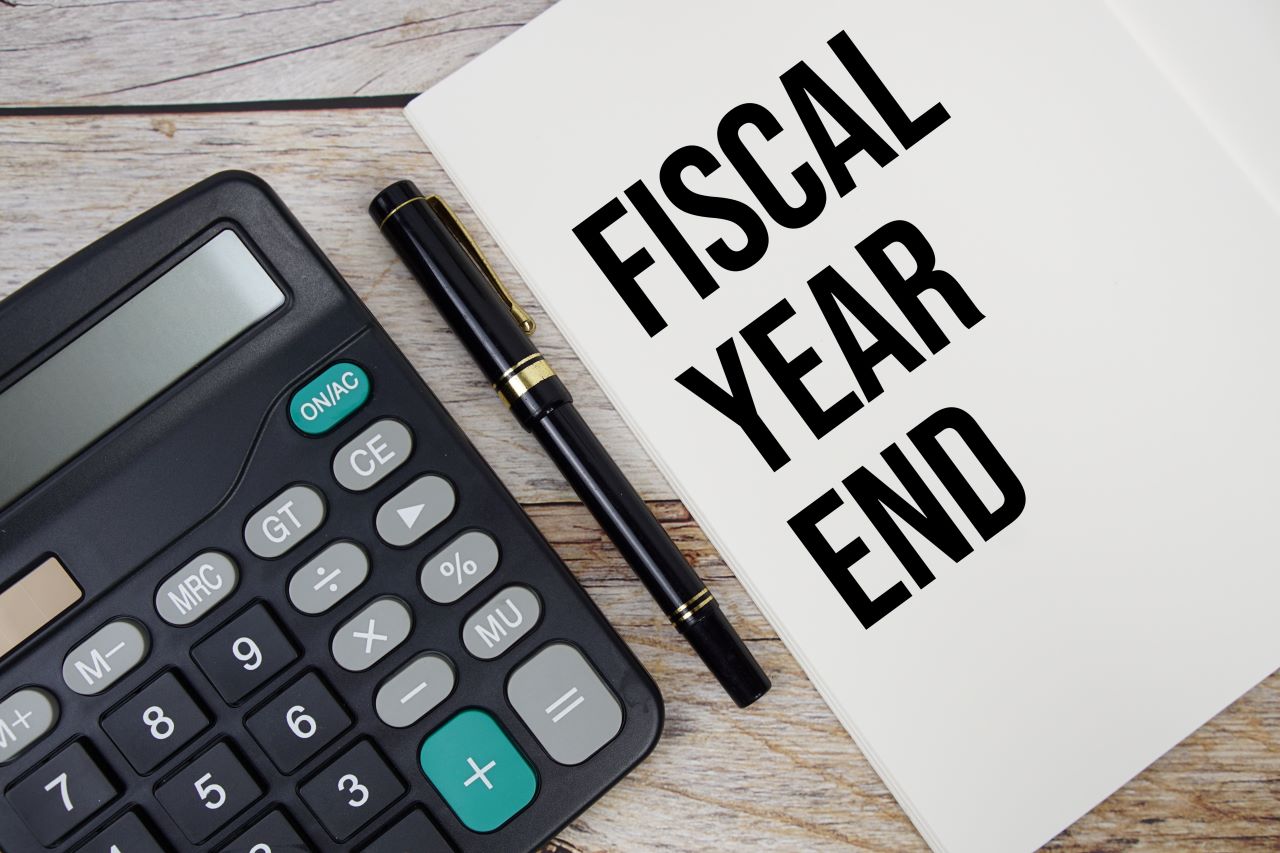 Image of a calculator next to a sheet of paper reading Fiscal Year End.
