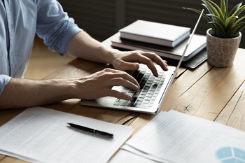 Hands of a person typing on a laptop