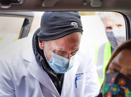 National Jewish Health President Michael Salem, MD, administers a vaccine outside St. Cajetan Catholic Church