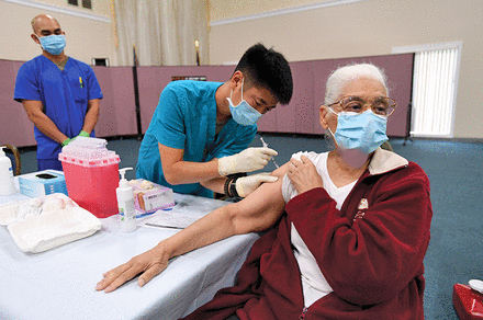 Zemoria Harvey receives a COVID-19 vaccination from EMT Sohei Yamaguchi in Long Beach, California, in February. 