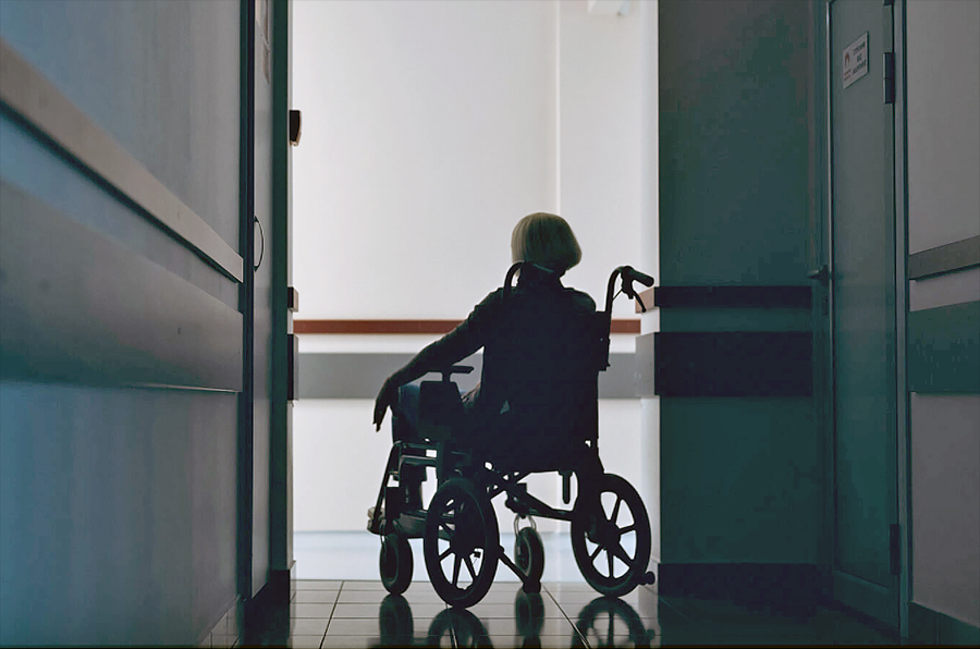 Woman in wheelchair, navigating health facility