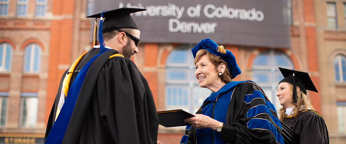 Student and Chancellor at CU Commencement