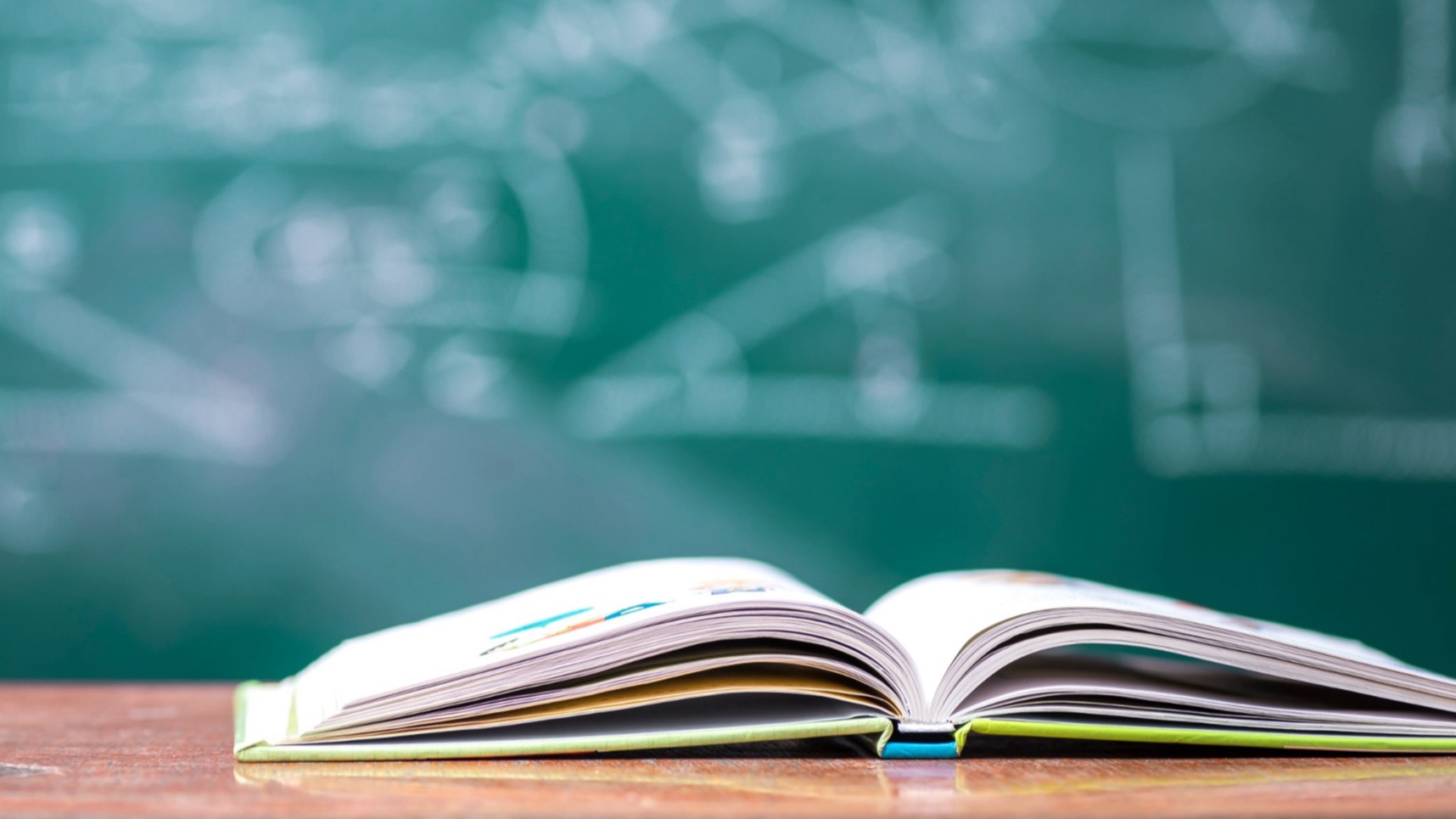 Open book in front of a blackboard
