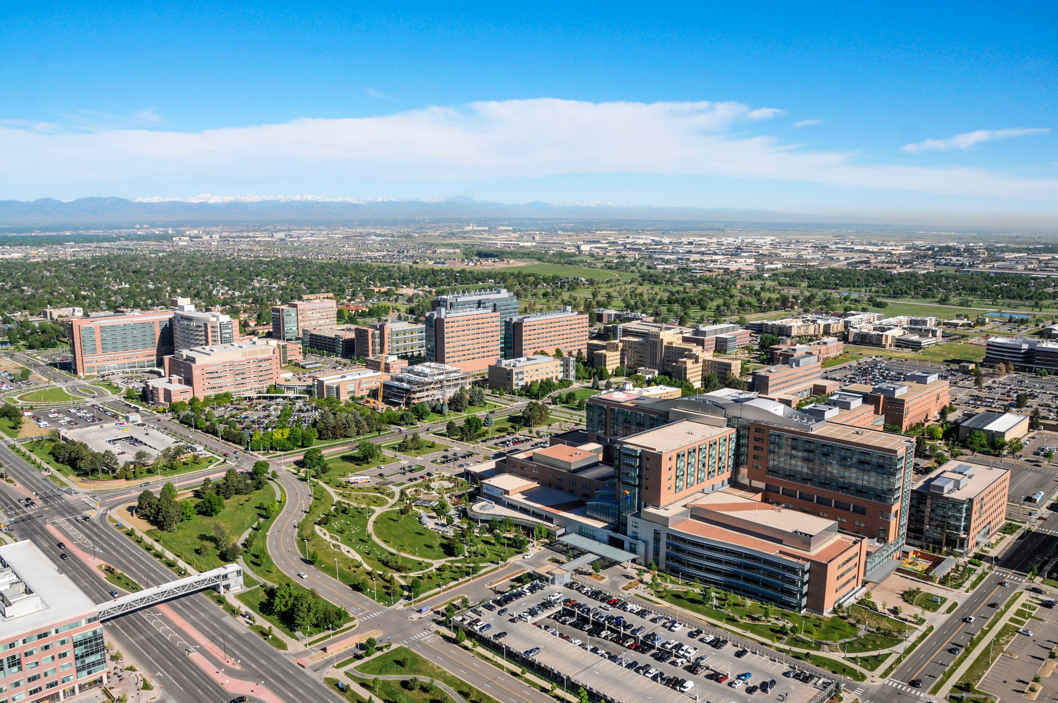 Aerial view of the University of Colorado Anschutz campus. The campus is in the foreground and the Front Range mountains are in the far background.