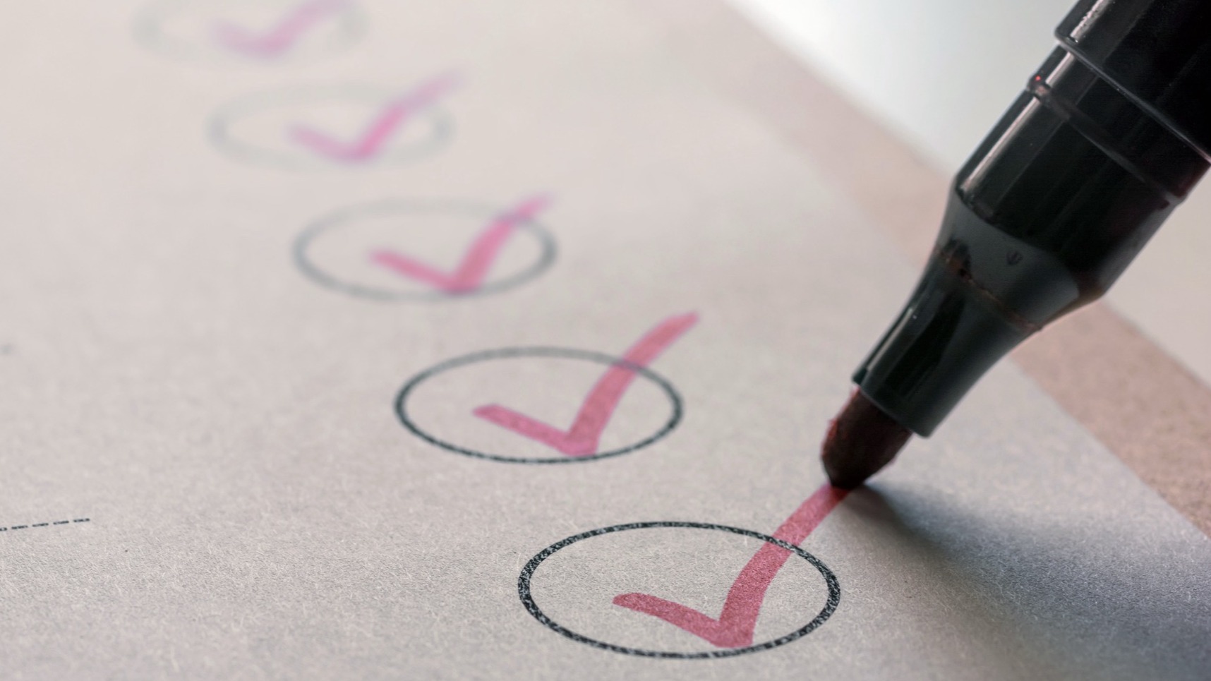Pen checking off checklist items