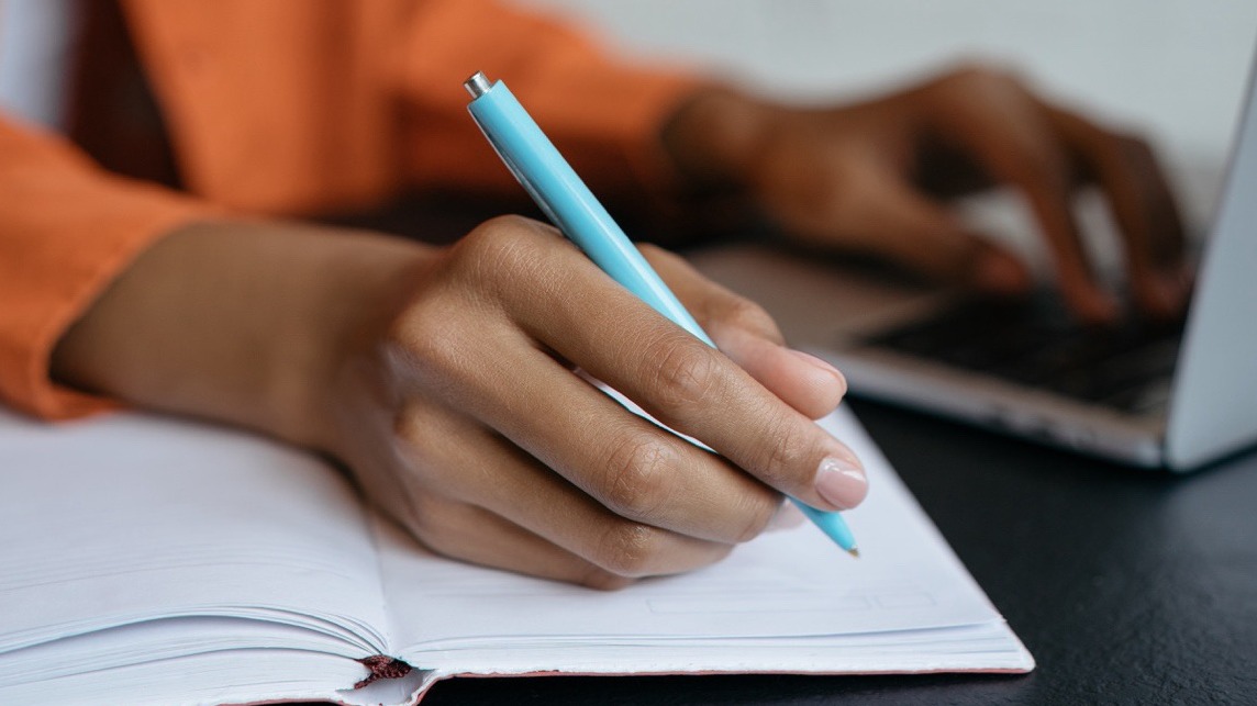 Hand taking notes with a pen