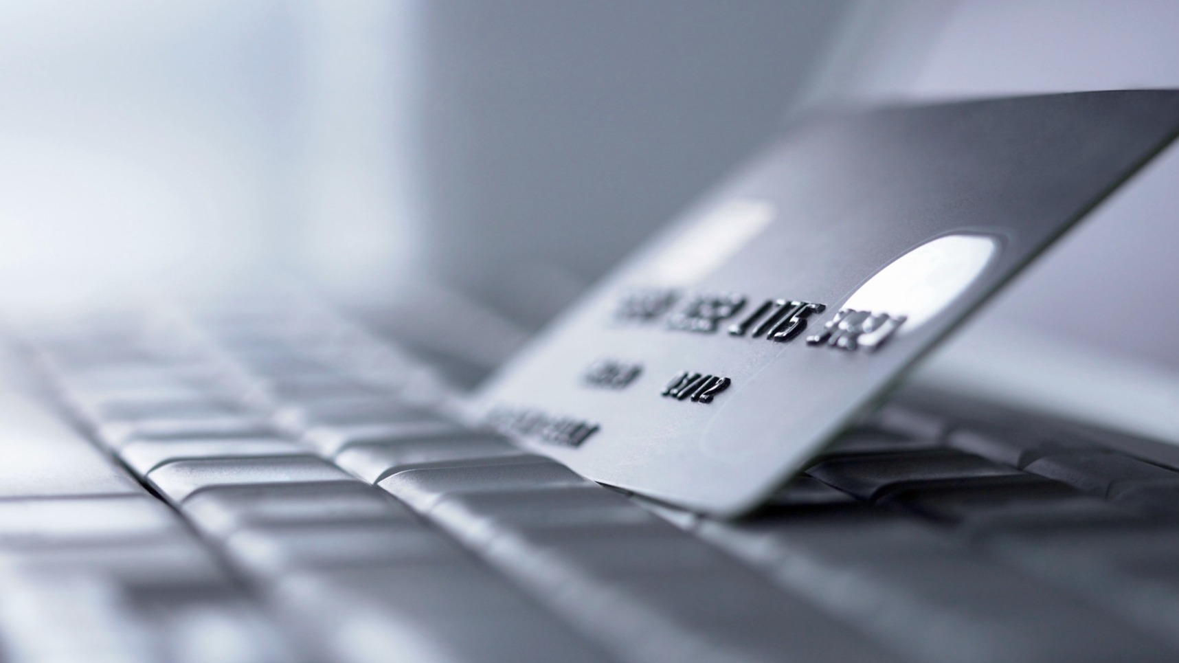 Credit card balanced on laptop keyboard