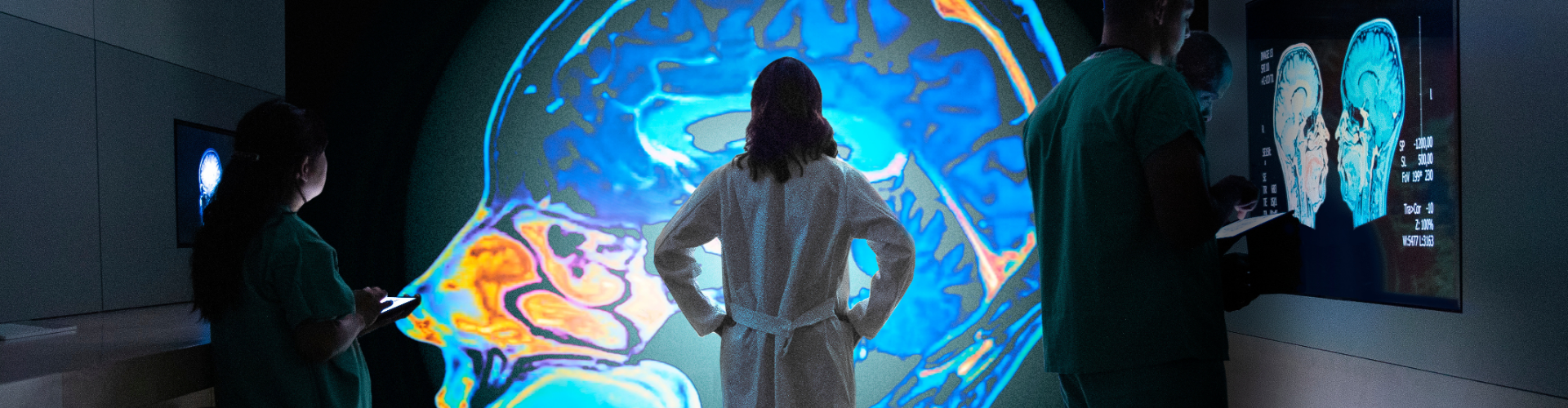 three doctors looking at images of brain scans