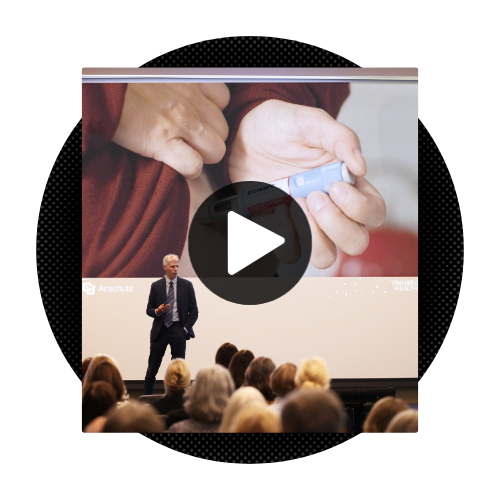 image of a man giving a presentation with a black and white 'play' button over the image