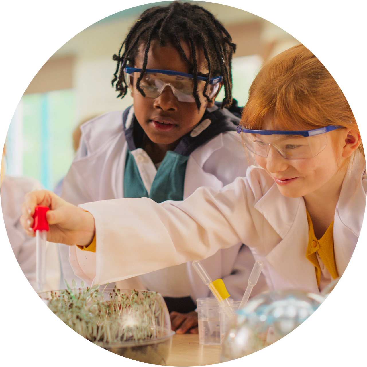 two children in PPE conducting a science experiment