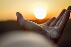 Hand outstretched toward setting sun Hand outstretched toward setting sun