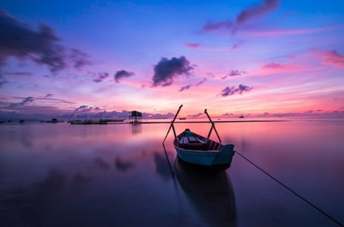 Rowboat on water at sunset