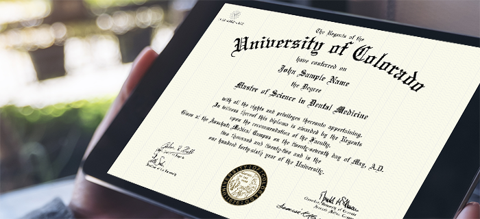 Image of a CU Anschutz student holding a University of Colorado degree