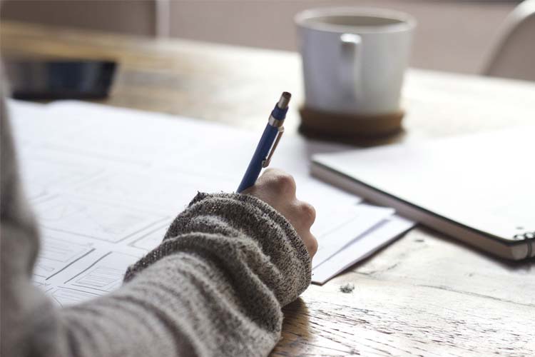 A person writing on a piece of paper.