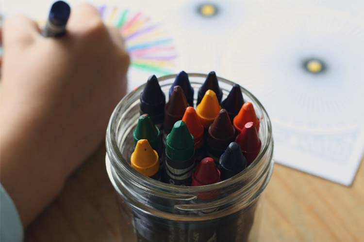 a child drawing with crayons
