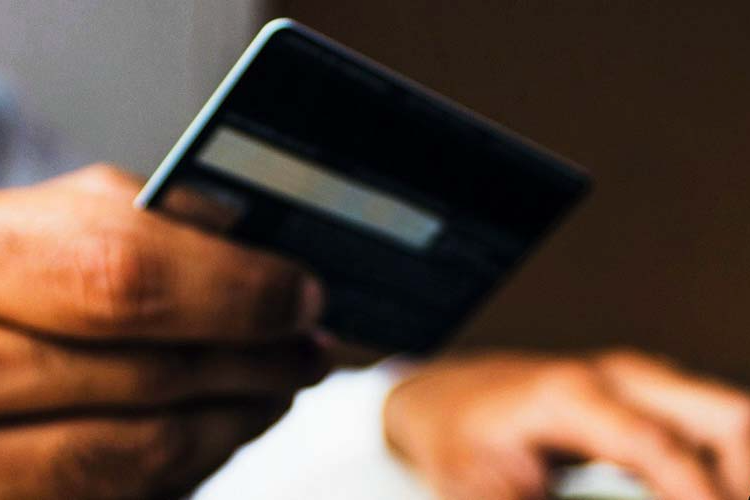 A person making a payment with their credit card on a laptop.