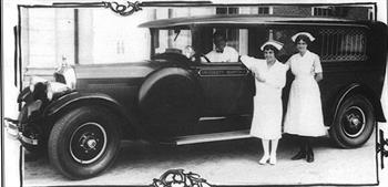 black and white photo nurses standing by ambulance