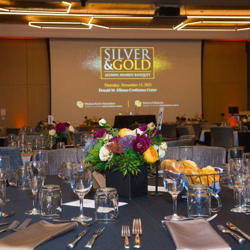 A dining table decorated with a bouquet of flowers, ready for guests to take their place during the 2025 Silver and Gold celebration.