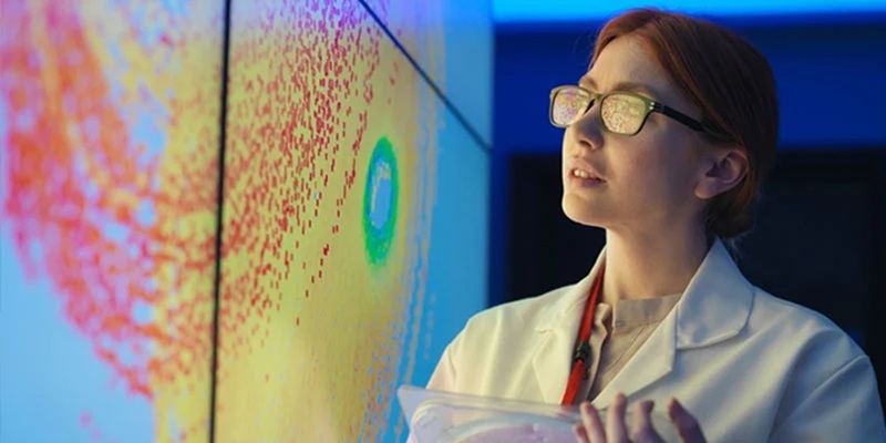A scientist studies a projected scientific image on a wall.