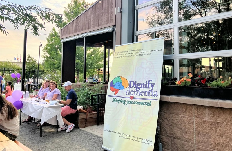 Volunteers work a stall at a Dignify Dementia outdoor event