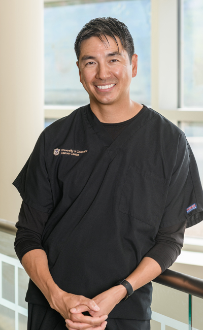 A photo of Dr. Lieu wearing black scrubs and standing in the outpatient cancer pavilion.