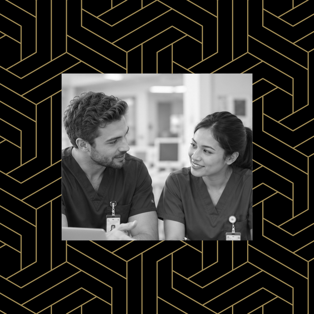 Man and woman wearing scrubs, smiling at each other while talking about work things