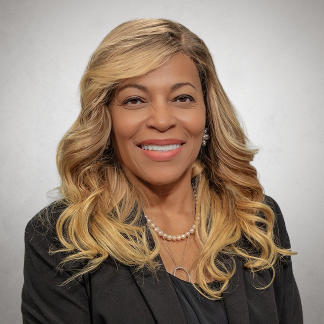 Dr. Regina Richards, smiling, wearing black, white background, indoors
