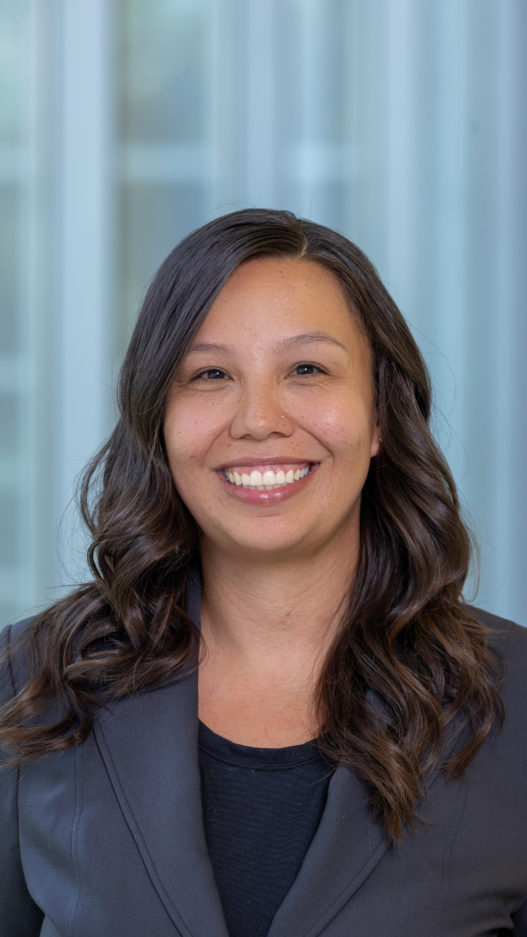 Rebecca standing smiling in front of blurred background