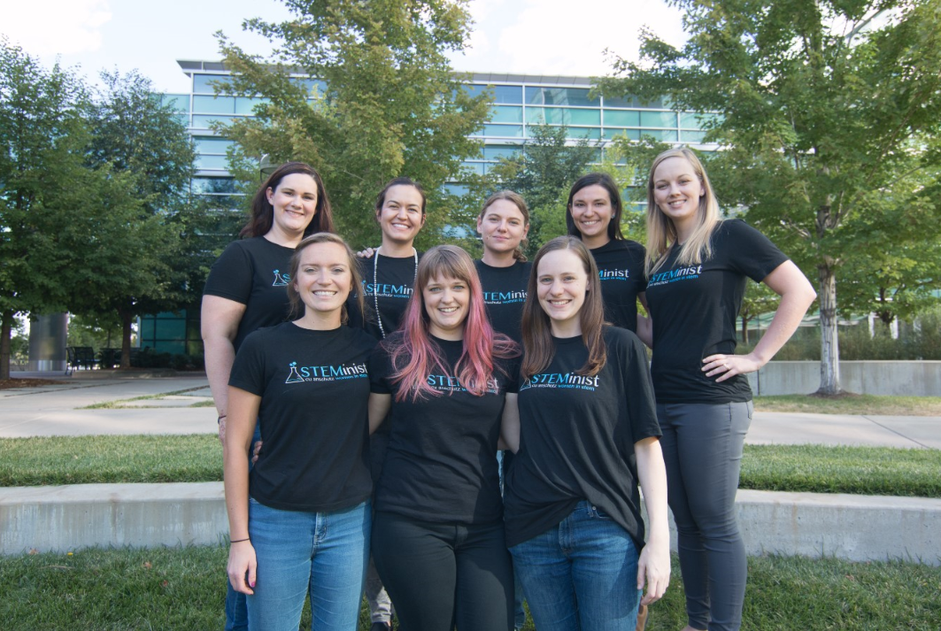 Eight women in two rows wearing matching 