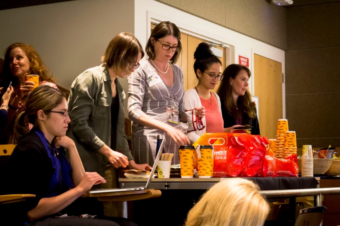 groupofpeoplegatheredaroundacoffeeandsnacktable