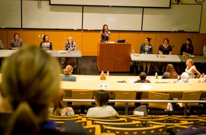 Speakeratpodiumsurroundedbypanelists