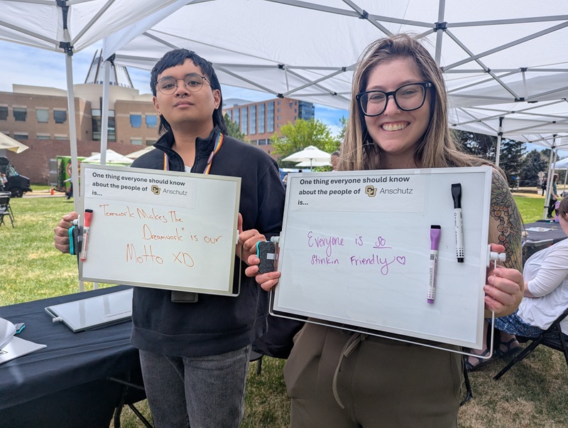 Mars and Ashley hold up their whiteboard for Faces of CU Anschutz campaign.